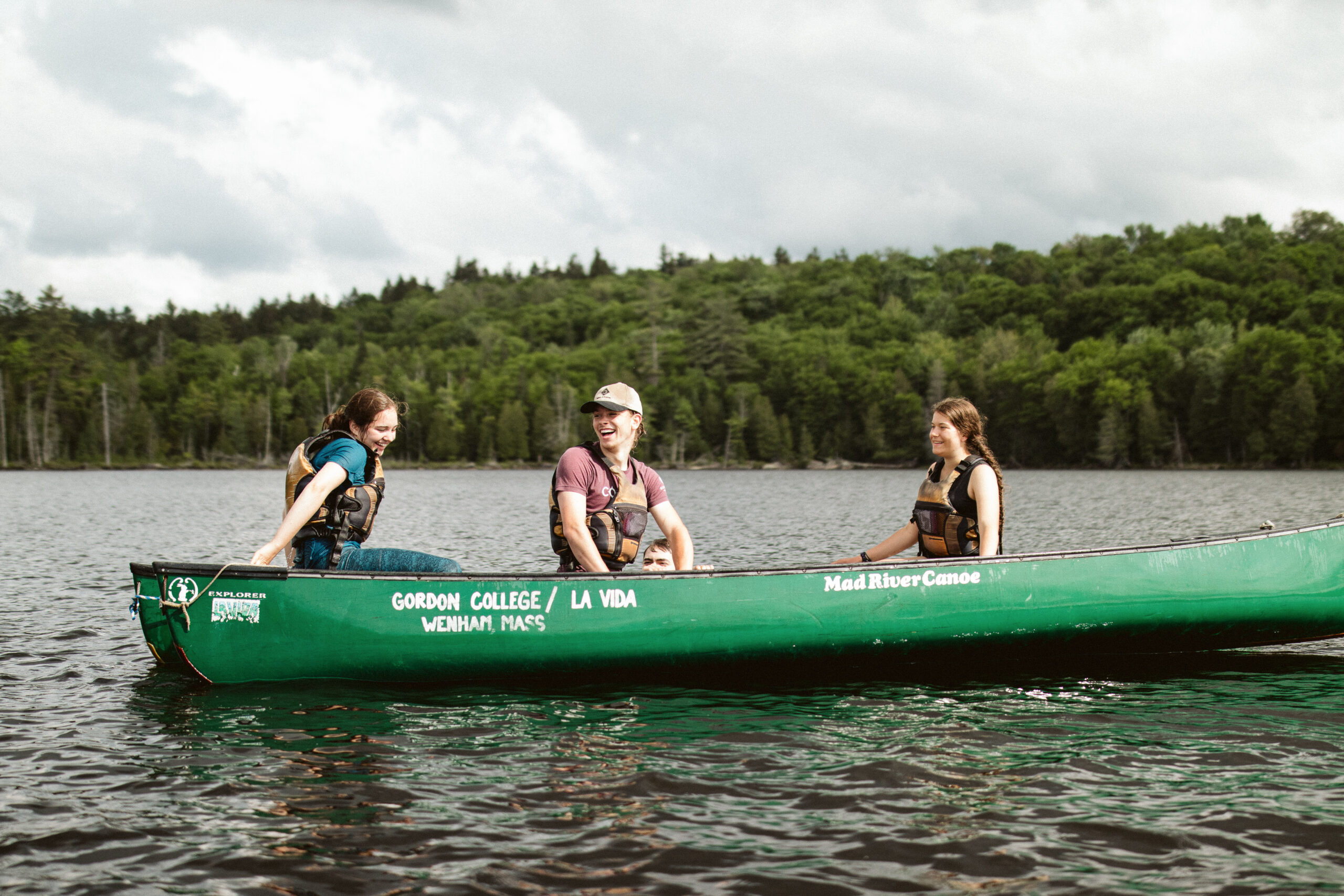 Three people canoeing on a pond